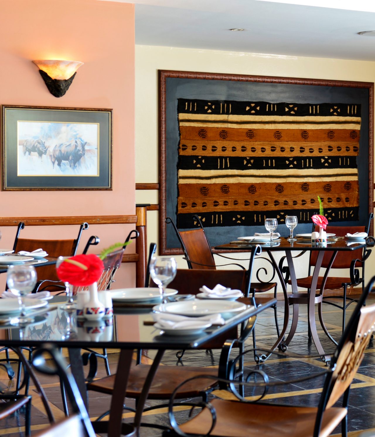 El restaurante Monomotapa, del Hotel 4 Estrellas en Maputo, tiene varias mesas con una flor roja y sillas