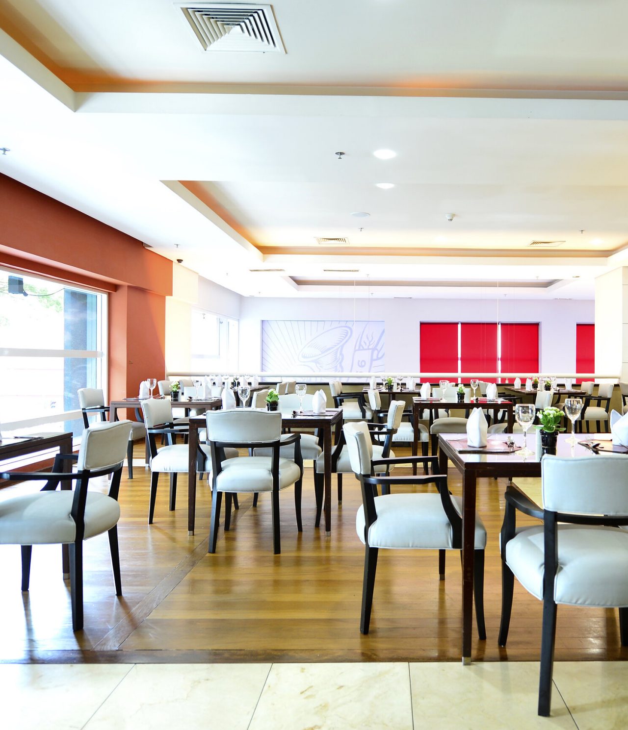 El restaurante Cais da Ribeira, del Hotel en Curitiba, Brasil, es amplio y tiene una ventana que deja entrar luz natural