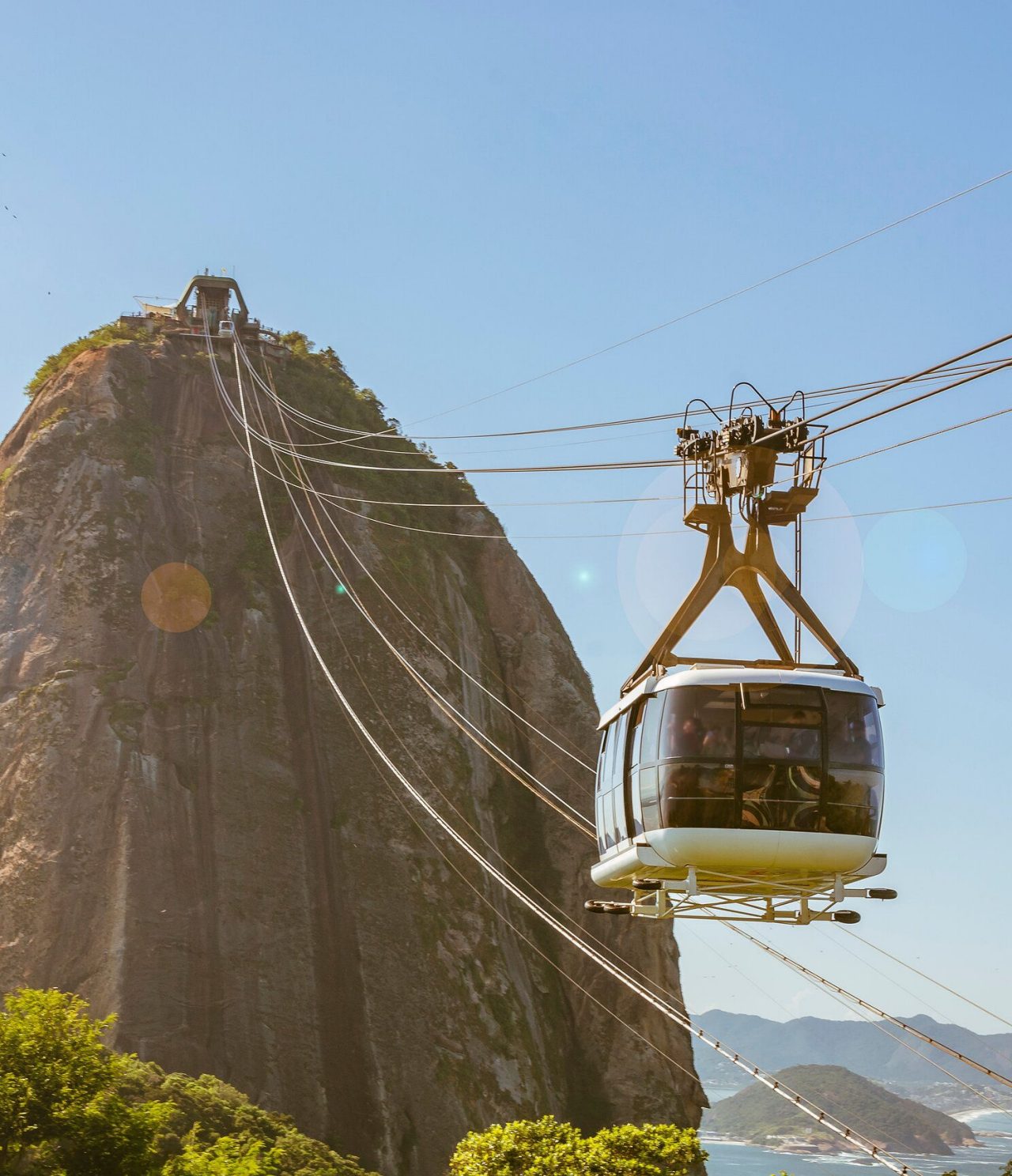 Vista del teleférico en Río de Janeiro, dirigiéndose hacia una colina alta, con el mar al fondo