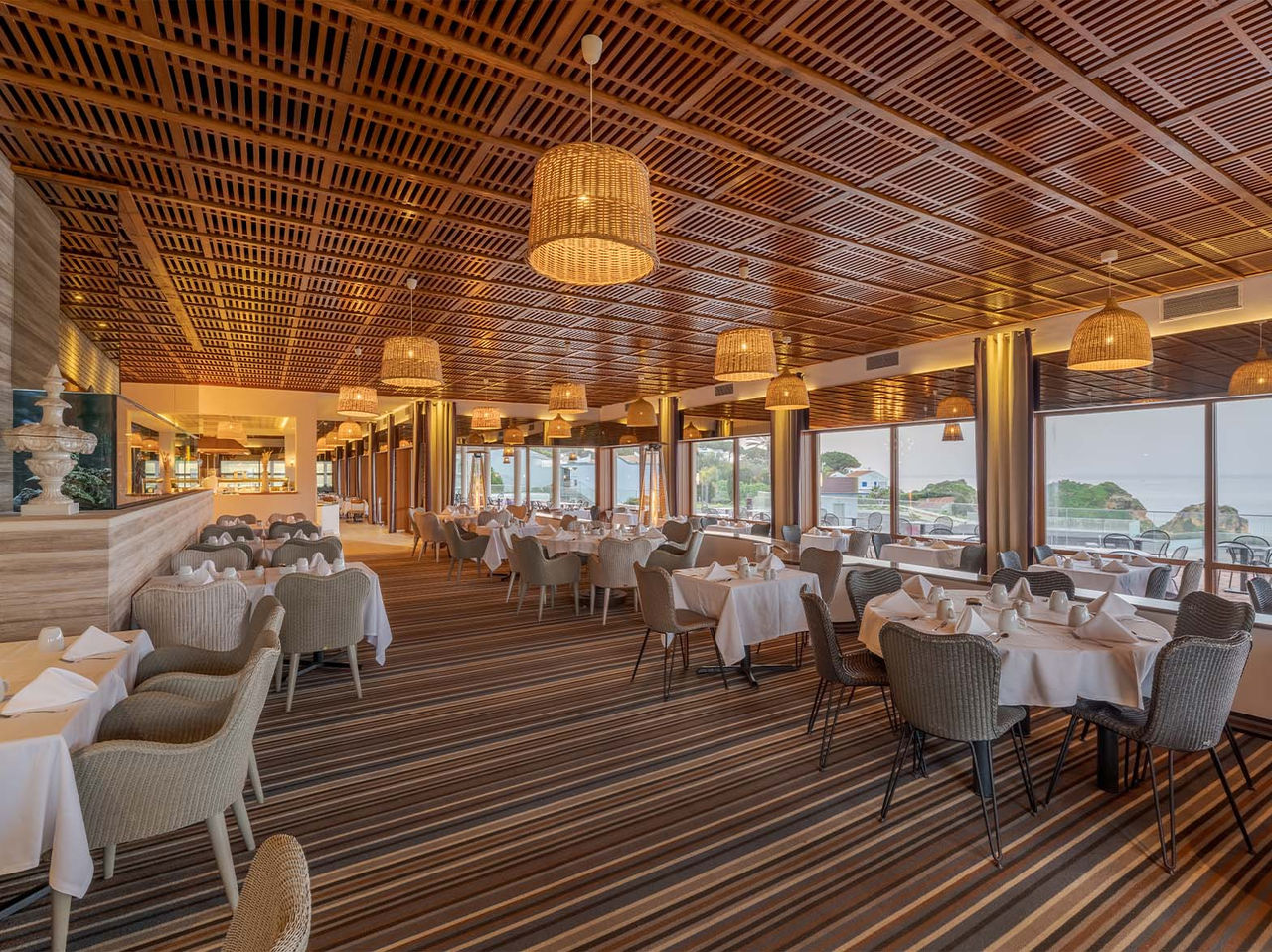 El restaurante Almofariz, del Hotel 5 Estrellas en el Algarve, tiene listones de madera en el techo y vista al mar