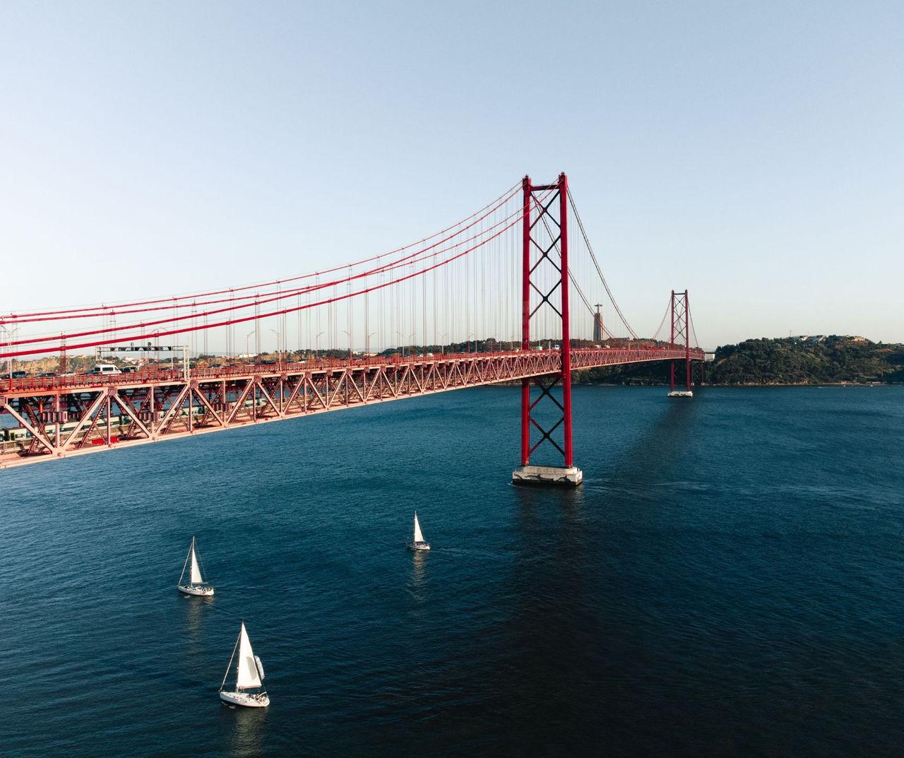 Vista panorámica de la ciudad de Lisboa, con el río Tejo y varios barcos, y el puente 25 de Abril