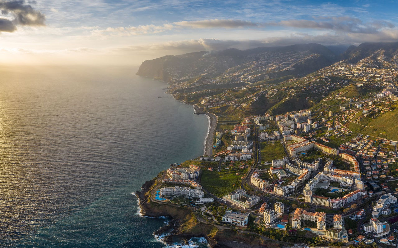 Vista aérea da cidade do Funchal, na Madeira, com áreas urbanas densas e montanhas ao fundo