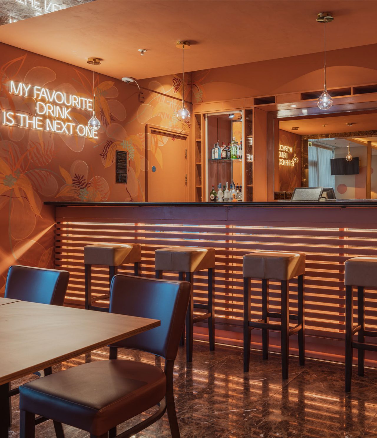 O bar The Bridge, do Hotel 4 Estrelas em Londres, tem um balcão com bancos altos e uma luz led na parede