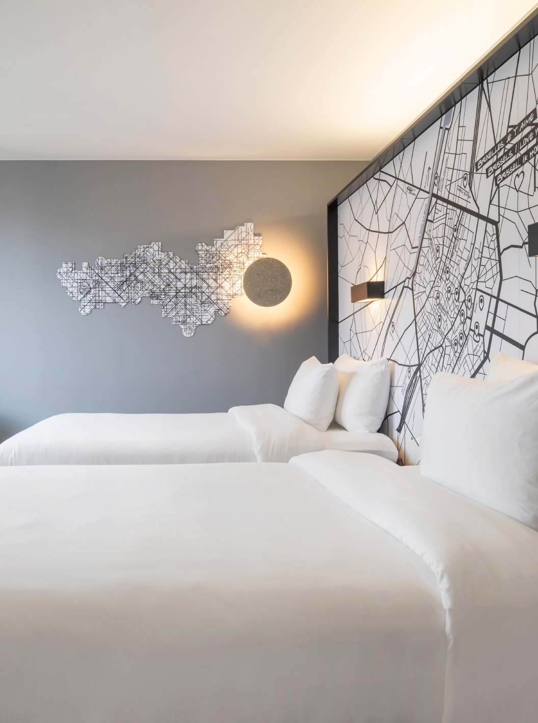 The Standard Twin at Pestana Brussels Schuman has two single beds, a yellow chair, and a window with a view