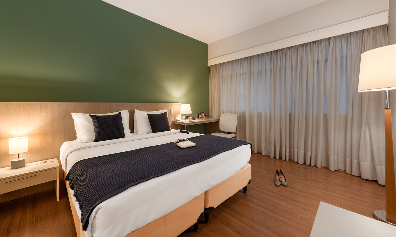The Superior Disable at Pestana Curitiba has a bed with a desk and a window beside it