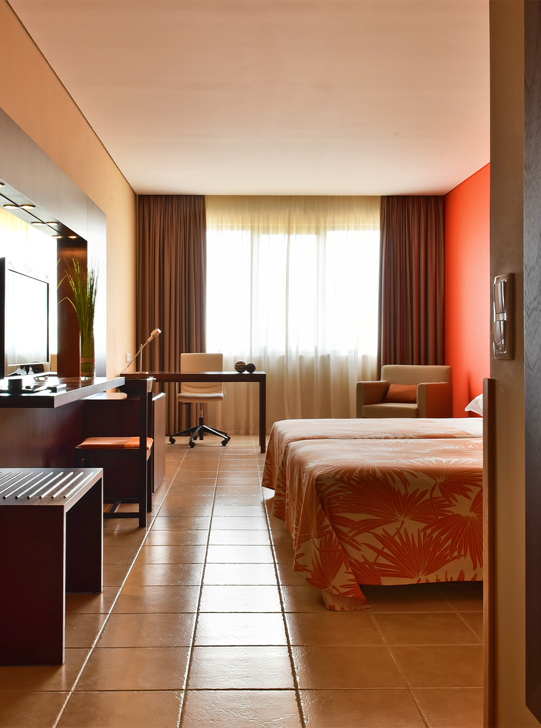 The Suite at Pestana Tropico features two single beds, desk, television, and an armchair