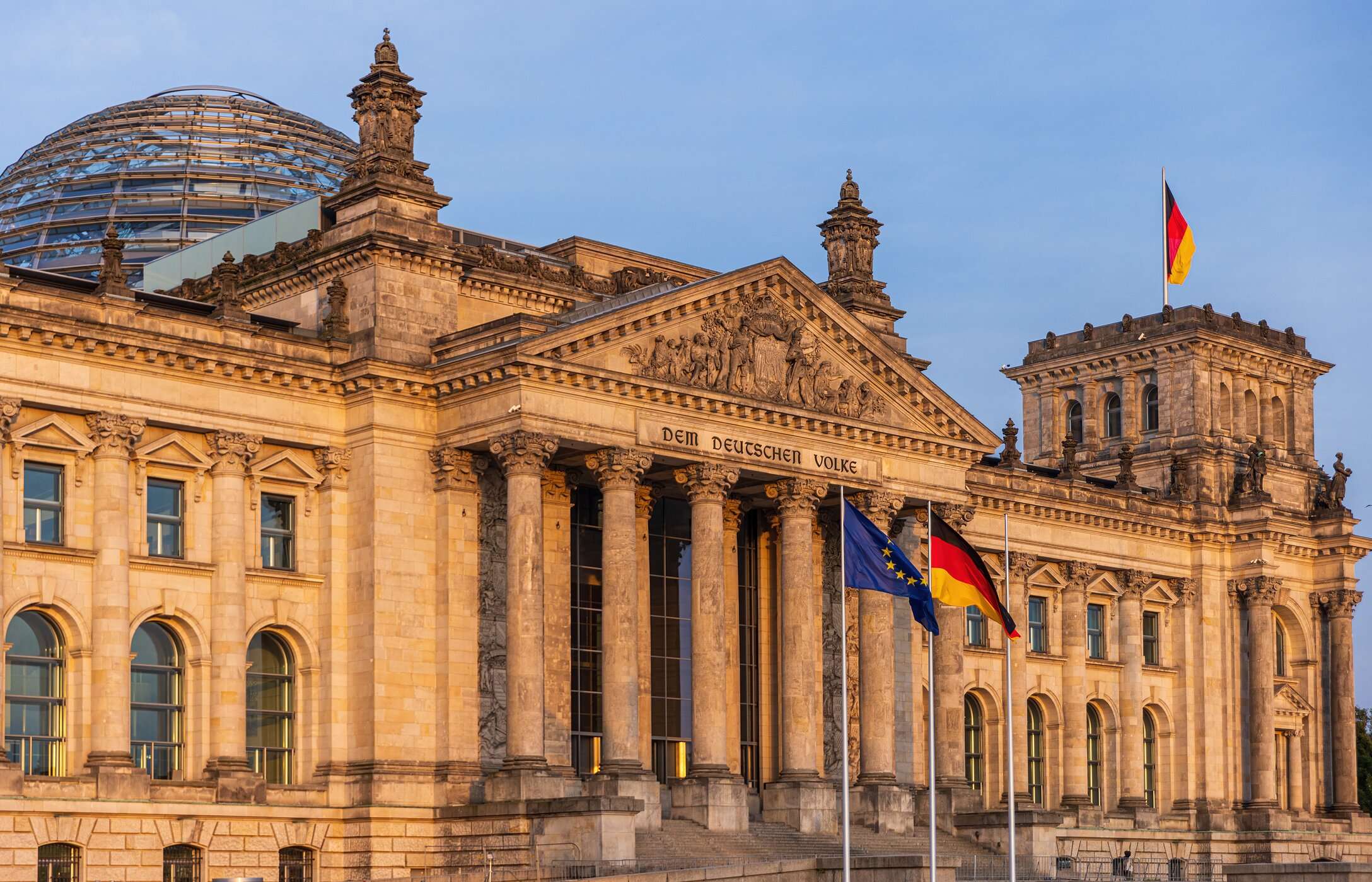 Front view of the Reichstag, the seat of the German parliament in Berlin, with a glass dome and the country's flag