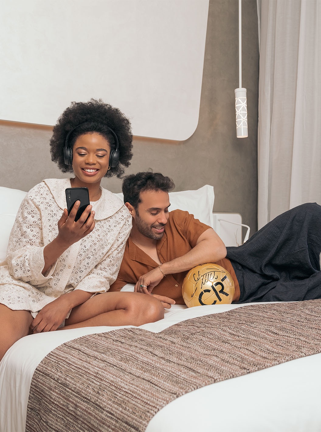 The CR7 Superior at Pestana CR7 Marrakech has a double bed with a smiling couple and a CR7 football