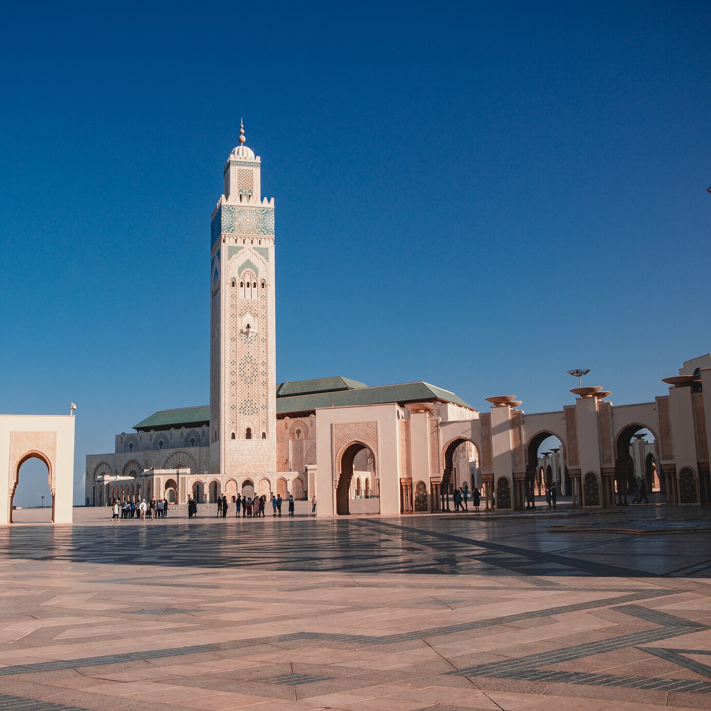 Stay at a Pestana hotel and explore the Hassan II Mosque in Casablanca, Morocco, with a large square in front.