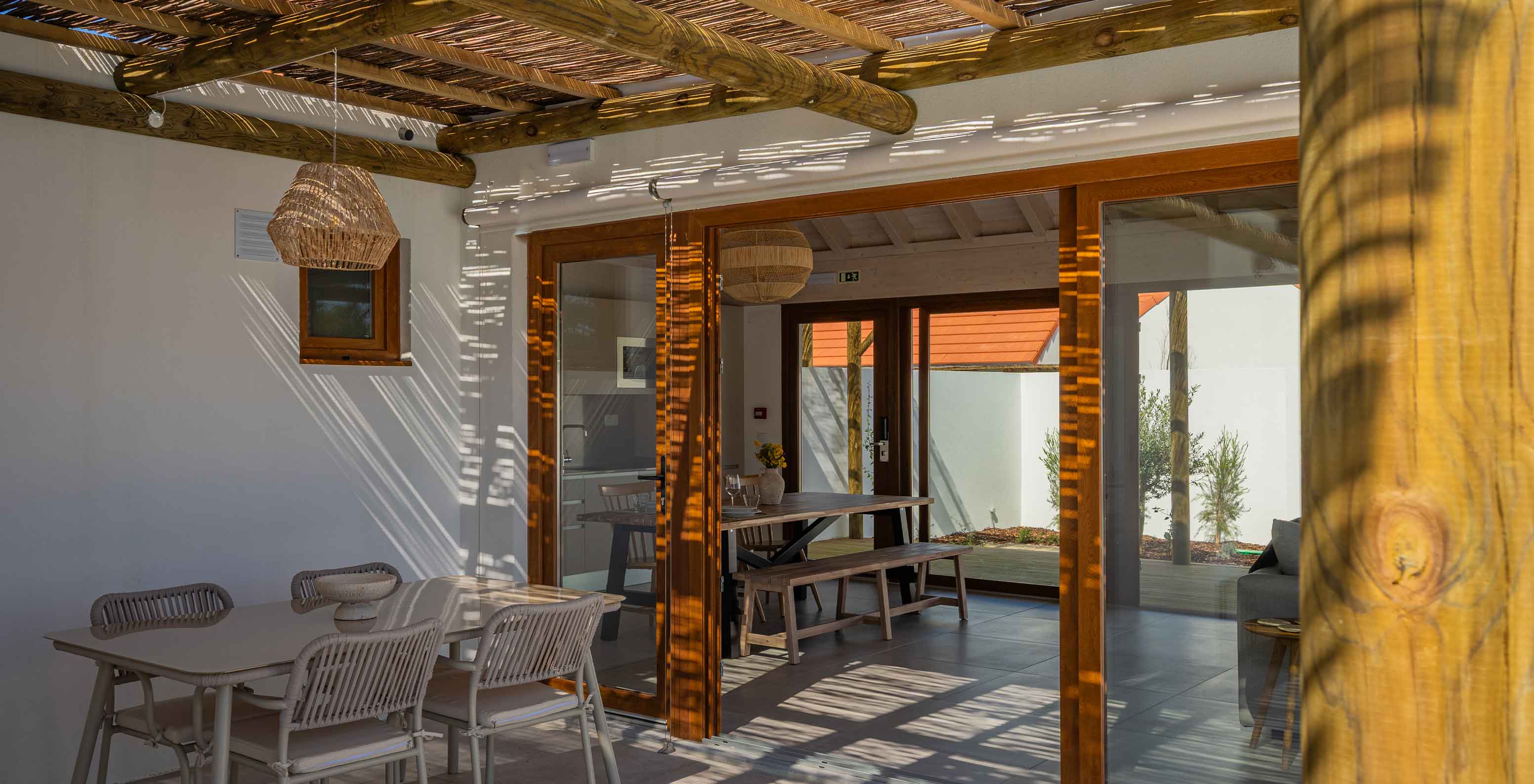 The Premium Green Villa at Pestana Comporta Village Residences has a covered patio with a table leading to the interior