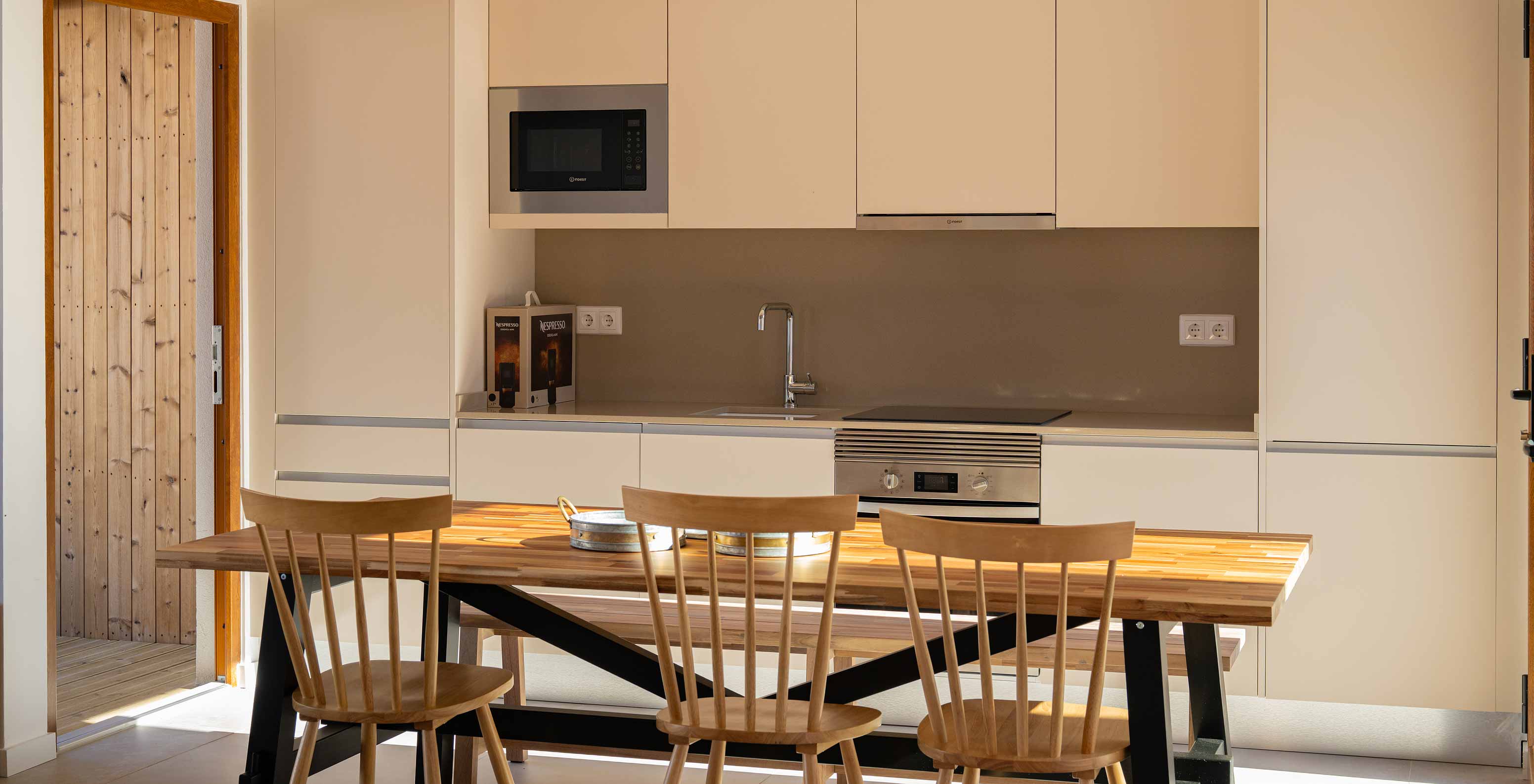 The Superior Villa at Pestana Comporta Village Residences has a modern kitchen with a wooden table and an oven