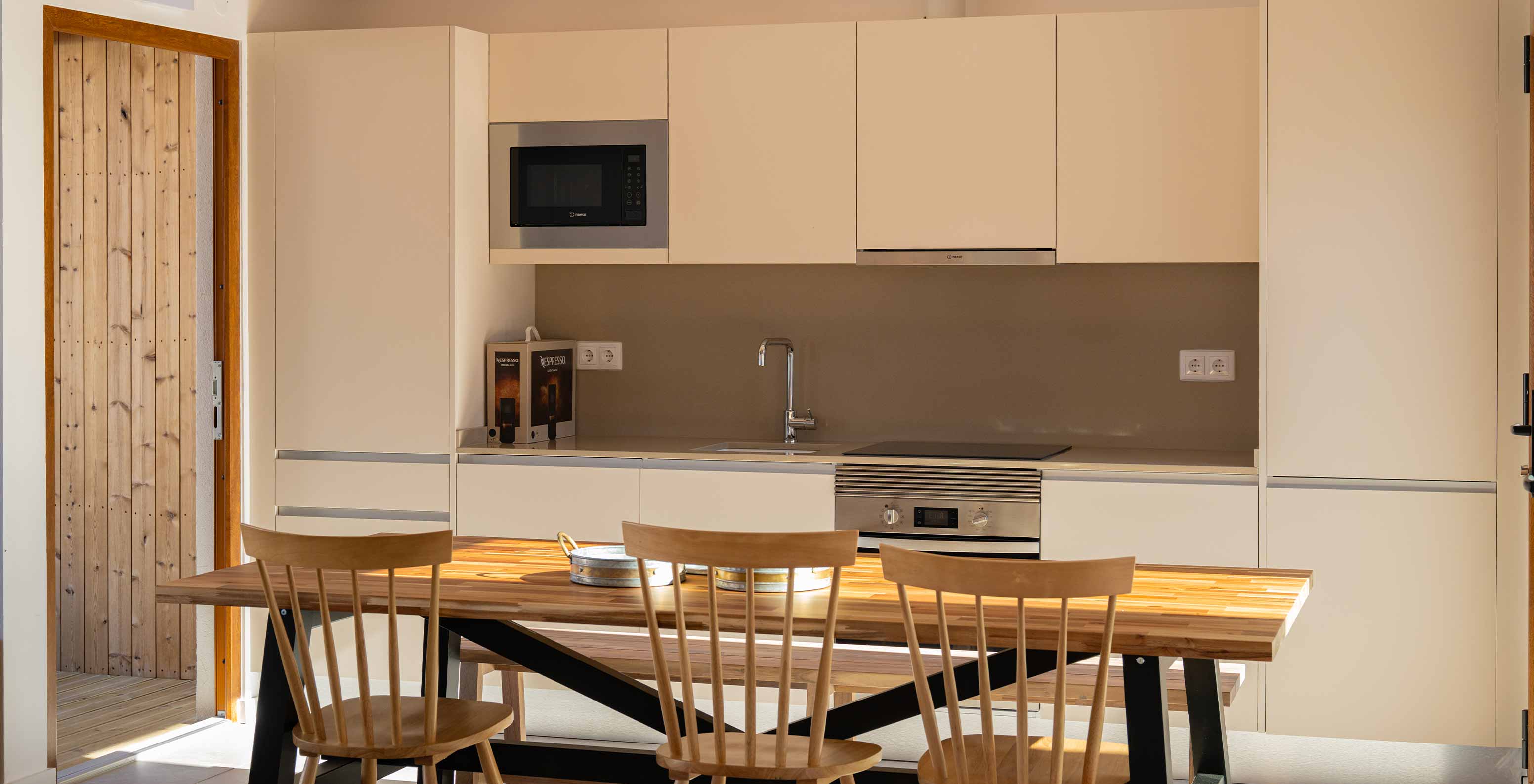 The Superior Green Villa at Pestana Comporta Village Residences has an equipped kitchen and a table with wooden chairs
