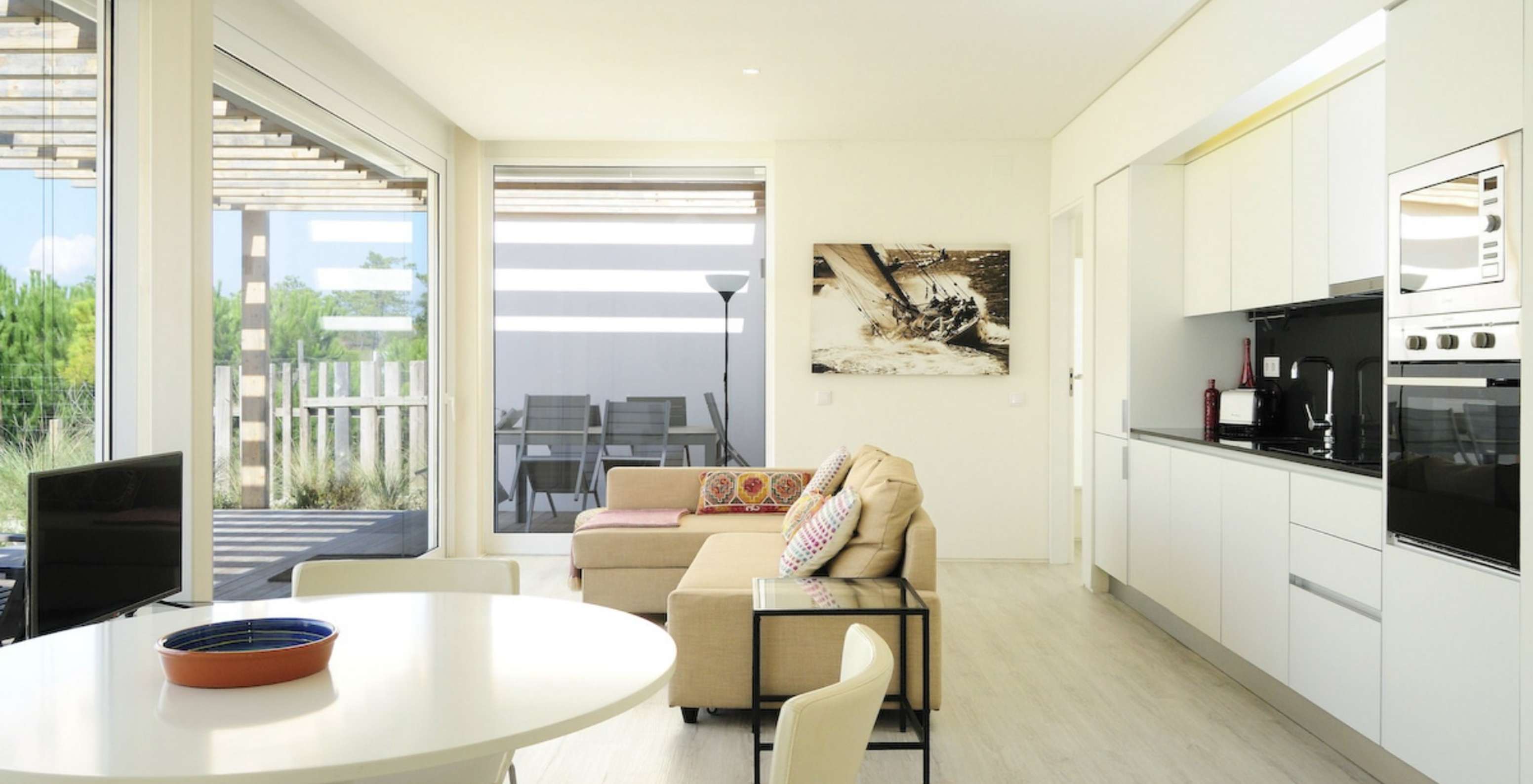 The Green T3 Villa of Pestana Tróia Eco Resort has a room combined with the kitchen, sofa, and dining table