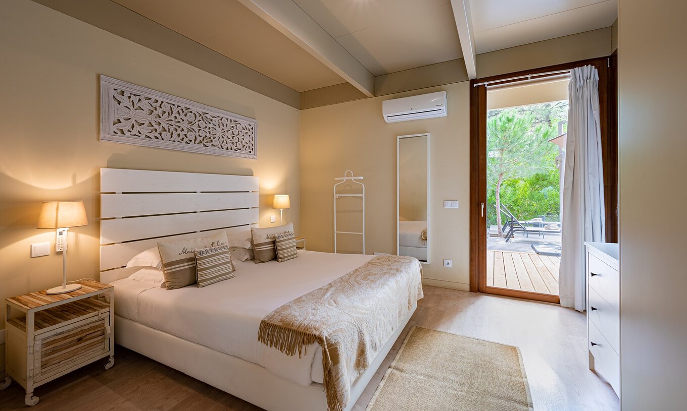 The Sand Villas with Private Pool of Pestana Tróia Eco Resort have a double bed with a bedspread and a mirror on the wall