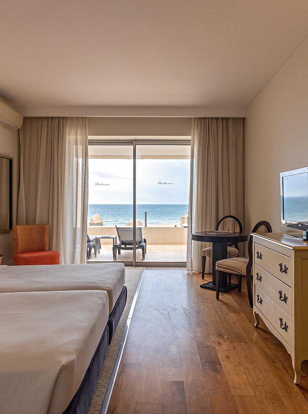 The Cliff Suite T1 at Pestana Alvor Praia has a double bedroom with a dresser, a television, and a balcony with a view