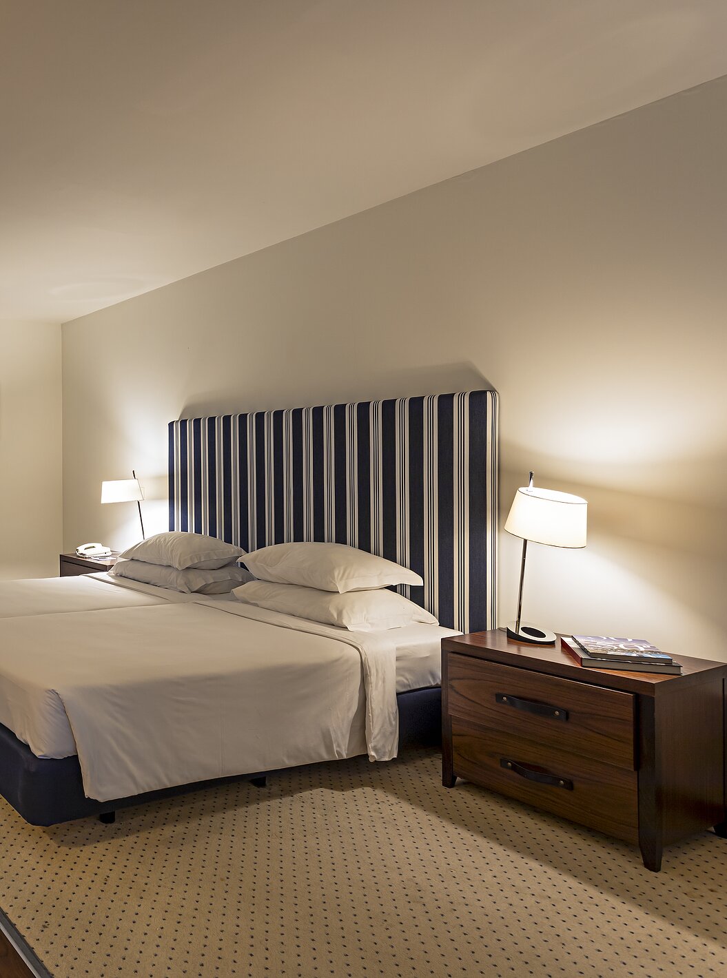 The Cliff Suite T2 at Pestana Alvor Praia has a large bedroom with a double bed, two paintings, and a dresser with a TV