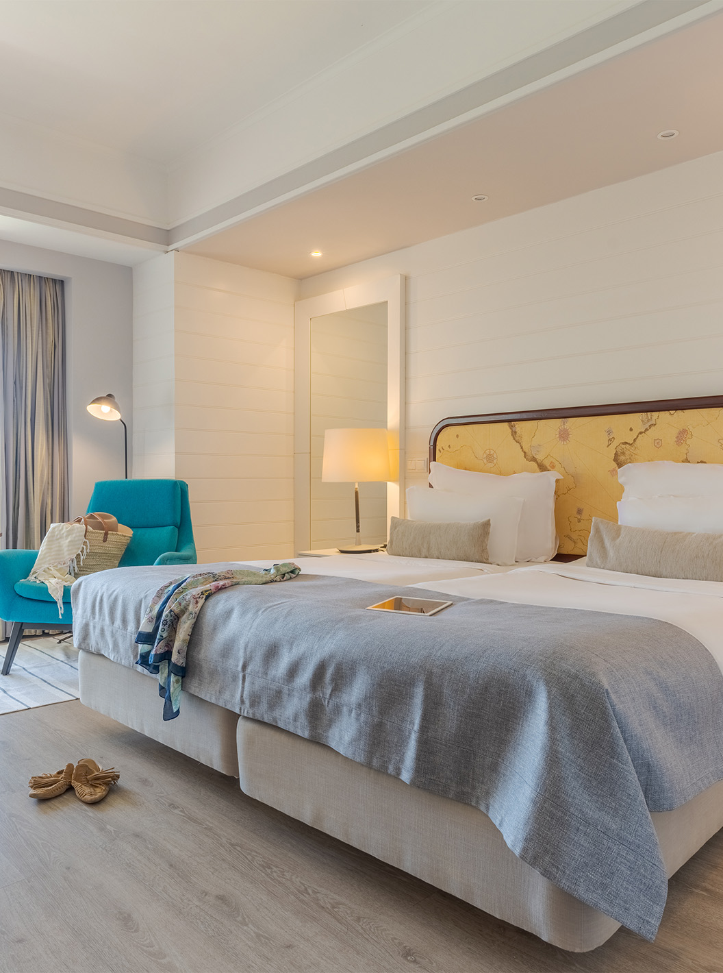 The Sea View Deluxe at Pestana Alvor Praia has two joined beds with a blue armchair and a balcony view