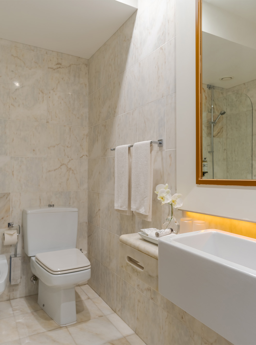 The Deluxe at Pestana Alvor Praia has a light marble bathroom with sink, mirror, toilet, bidet, and bathtub