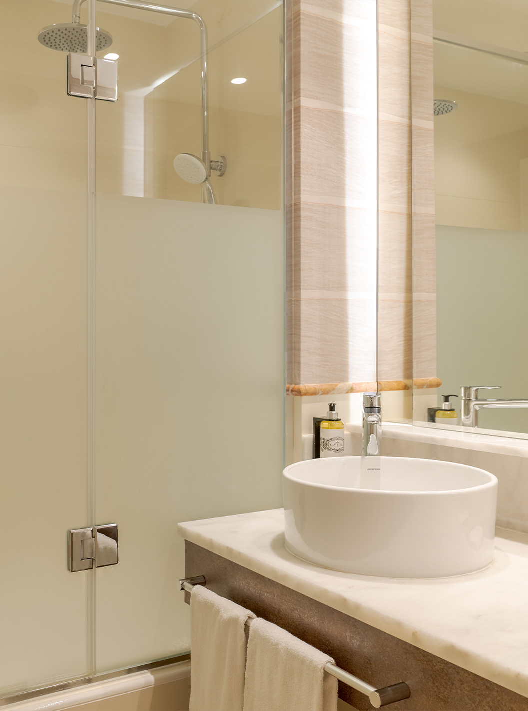 The Family Room at Pestana Blue Alvor Beach has a bathroom with a sink, mirror, towels, and a shower