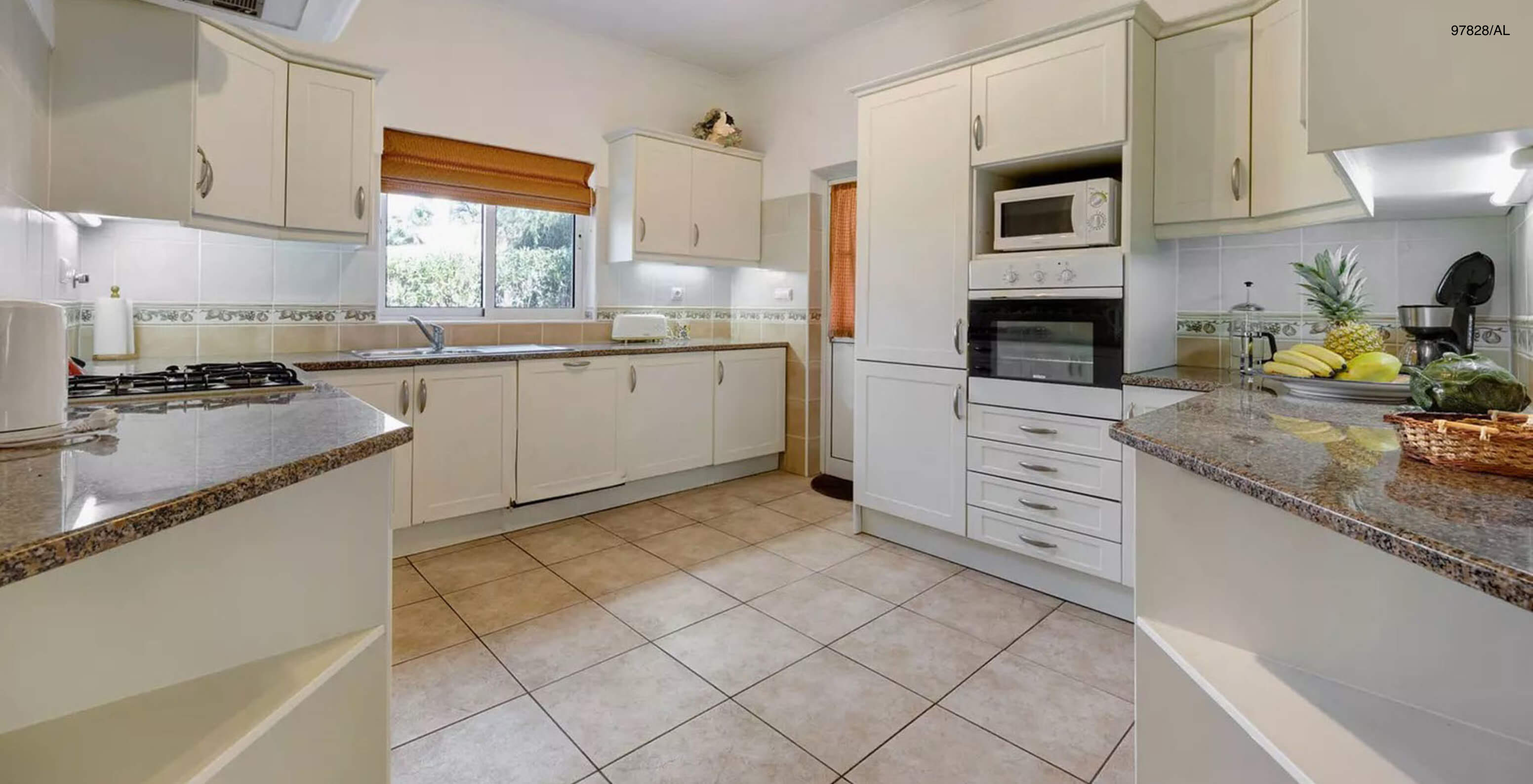 The Pestana Carvoeiro Golf V3 Standard Villa has a kitchen equipped with white cabinets and appliances