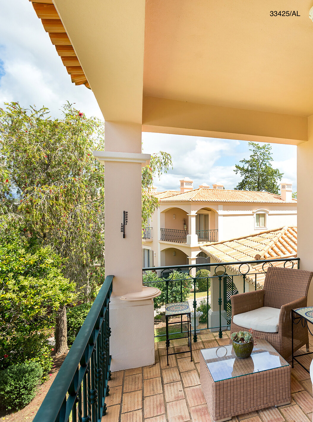 The Pestana Carvoeiro Golf T2 Standard Apartment has a balcony with a table, two chairs, and garden views