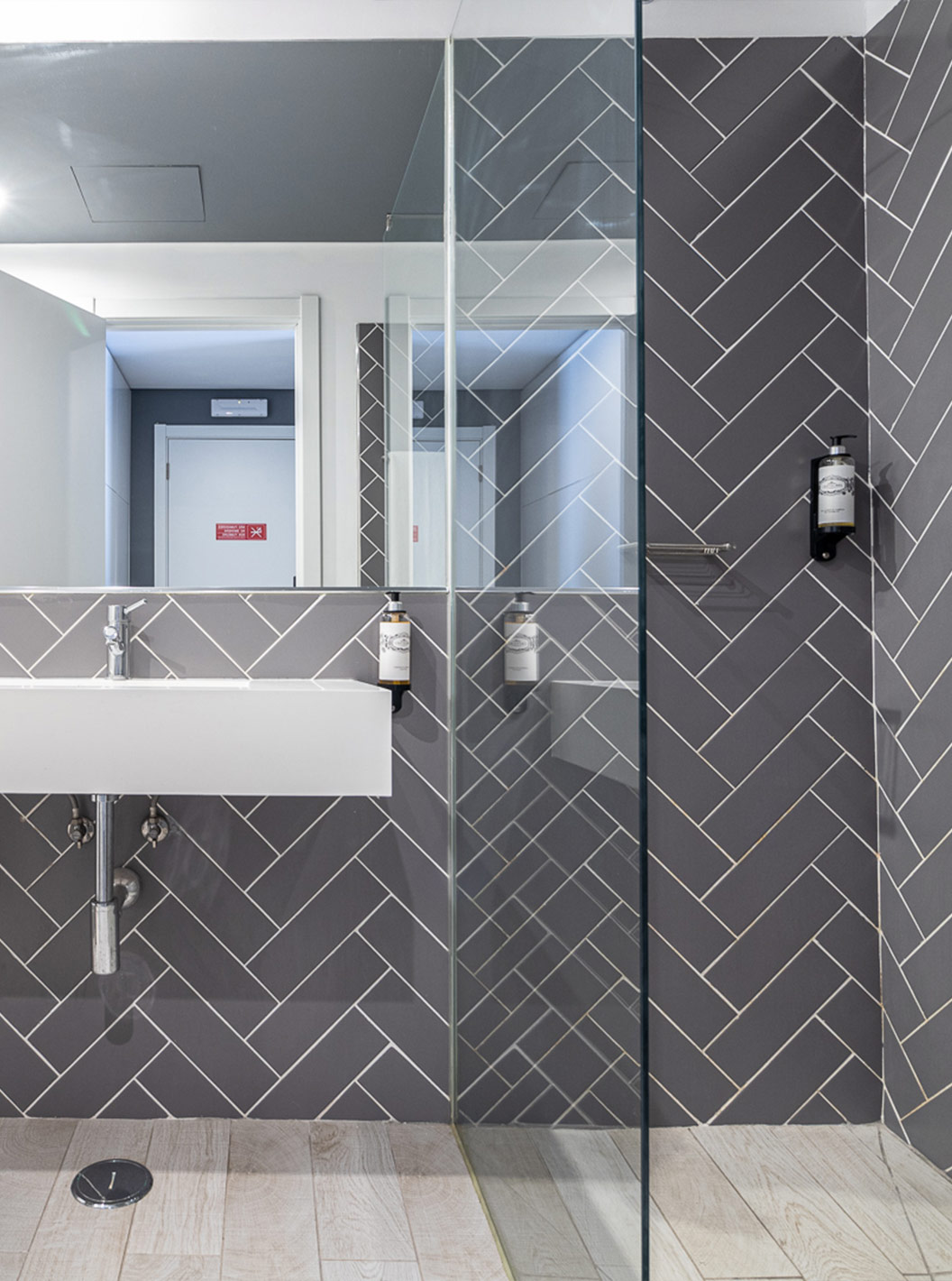 The Classic Pool View Room has a modern bathroom with white sink, mirror and glass shower