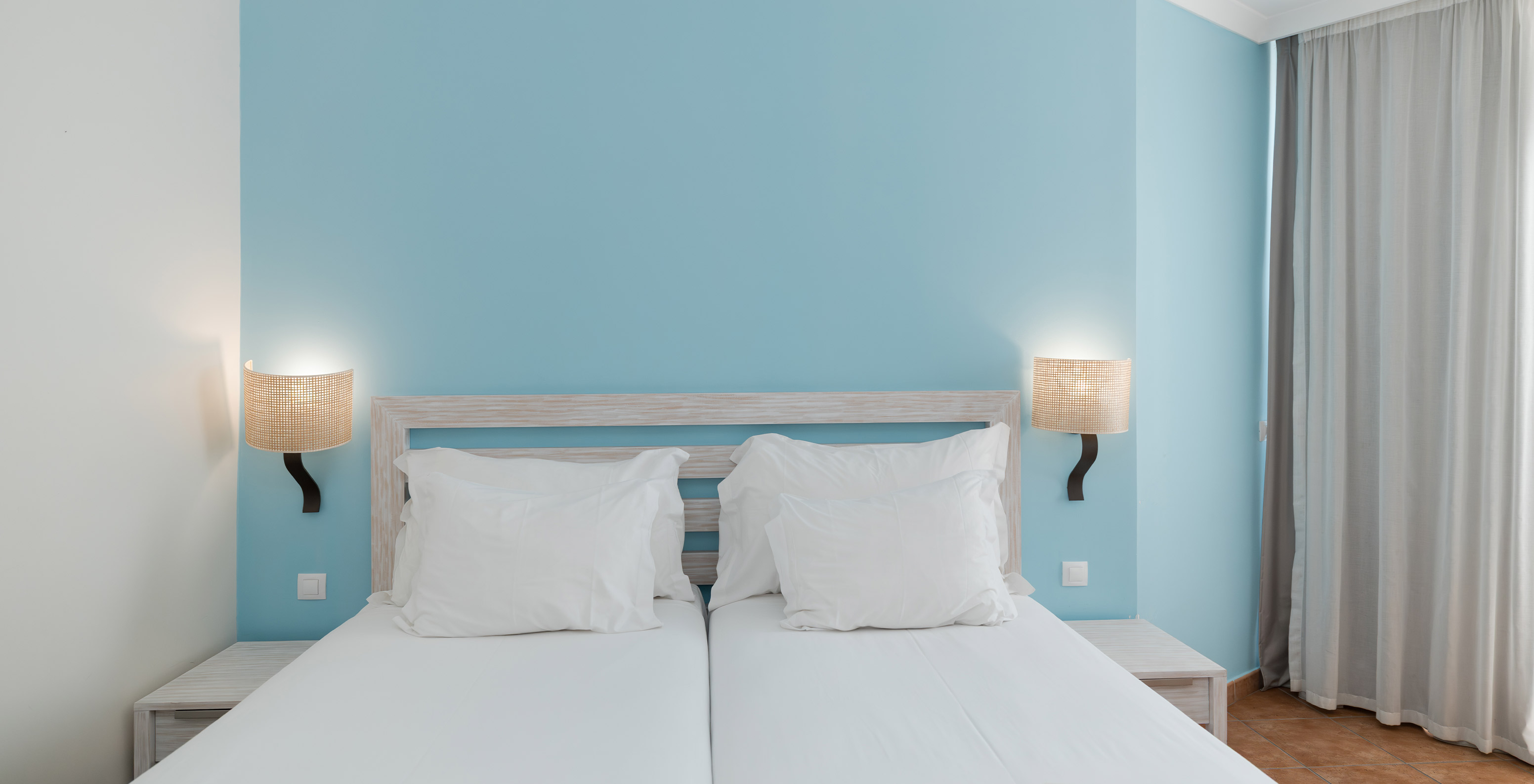 The Deluxe room at Pestana Viking features two single beds with lamp and bedside table