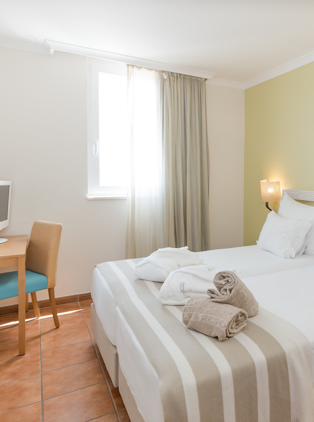 The Sea View Suite at Pestana Viking has a room with two beds, bedside table and desk with chair