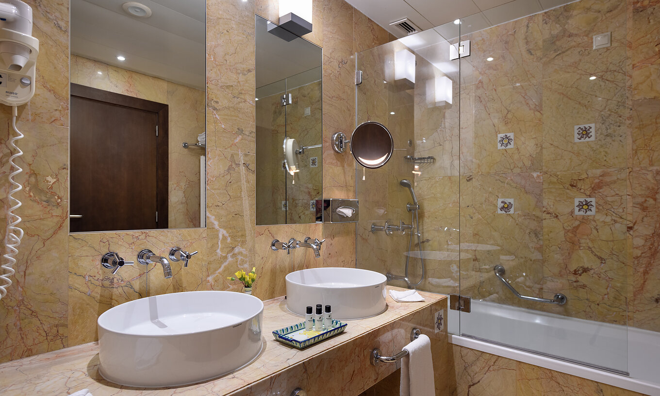 The Superior at Pestana Vila Sol - Vilamoura has a bathroom with two sinks, amenities and bathtub with shower
