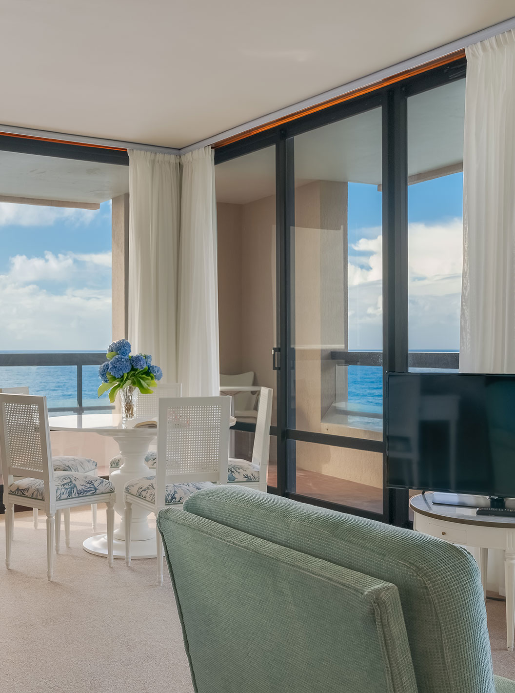 Suite at Pestana Bahia Praia has a living room with desk, table and sofa with TV, with a view of the sea