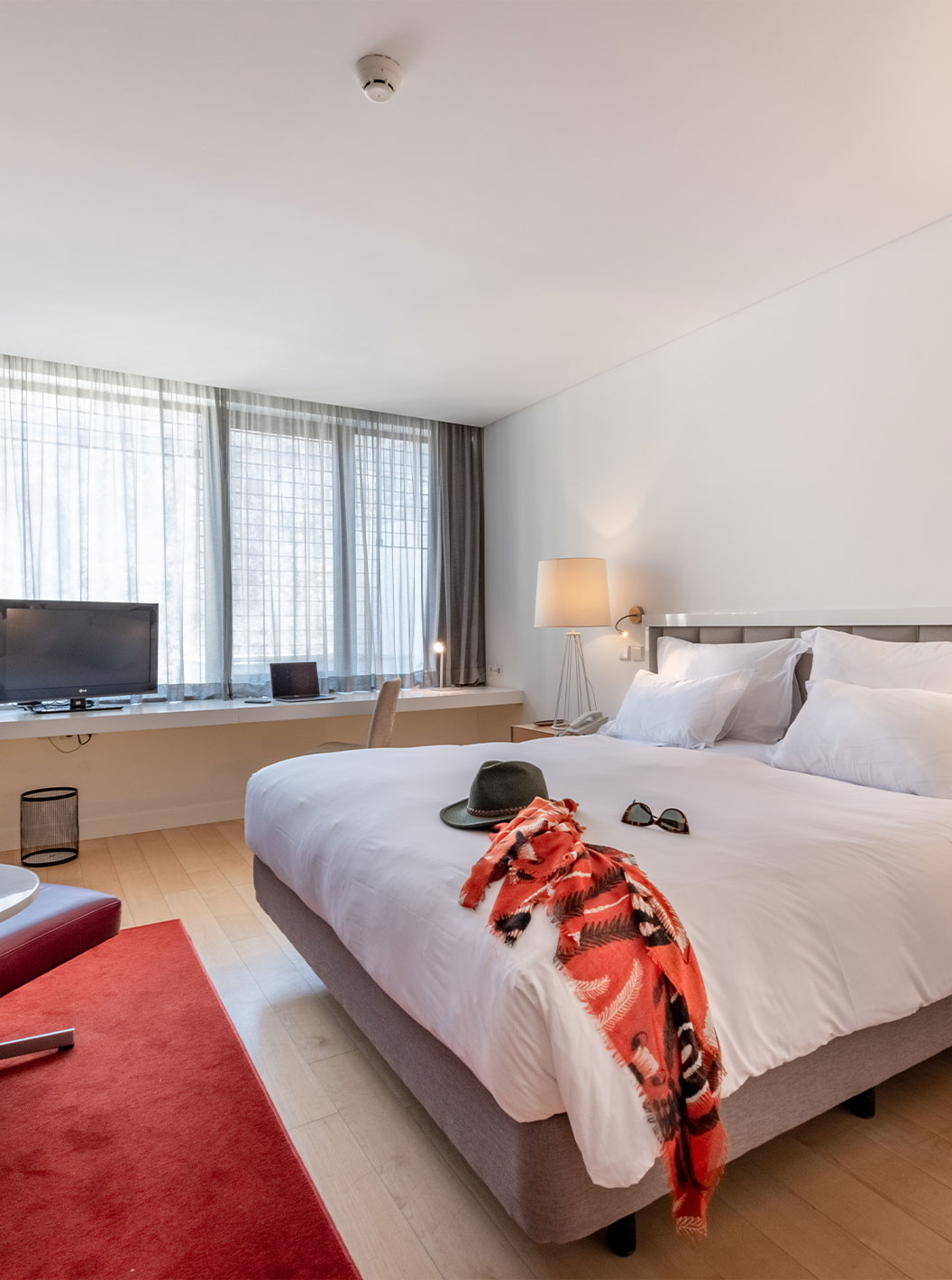 The Classic Room at Pestana Cidadela Cascais has a double bed, a TV, a red carpet, and a large window