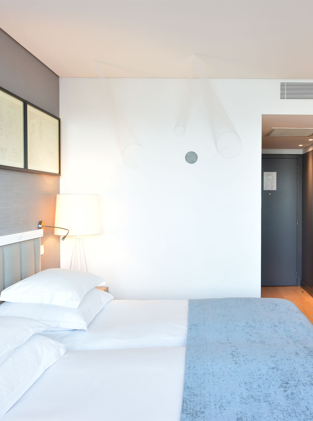 The Double Room Art District at Pestana Cidadela Cascais has a small hallway at the entrance, two beds, and an art wall