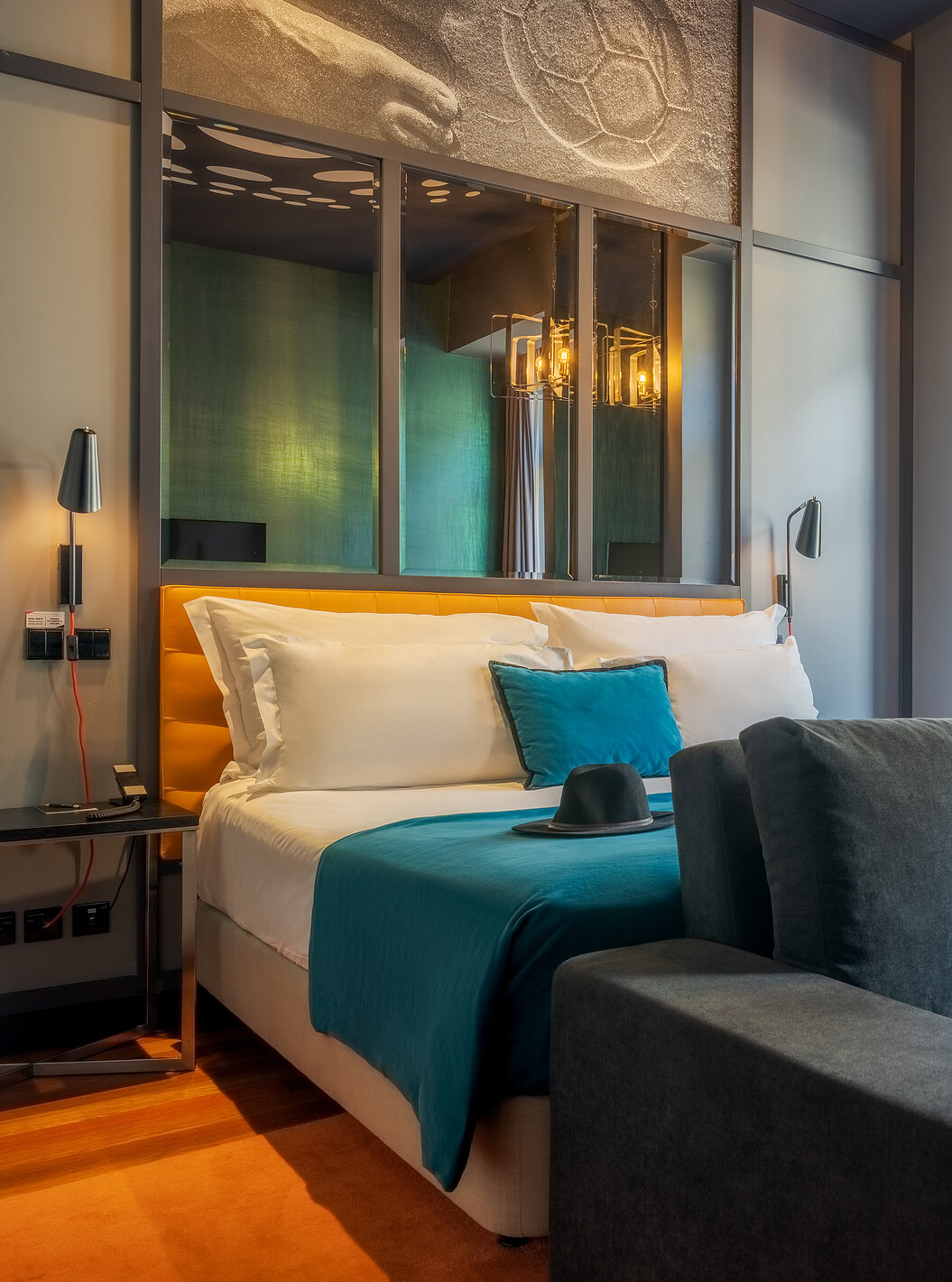 The CR7 Familiar Hat-Trick has a sofa a bed and a mirror above the bed at Pestana CR7 Lisboa