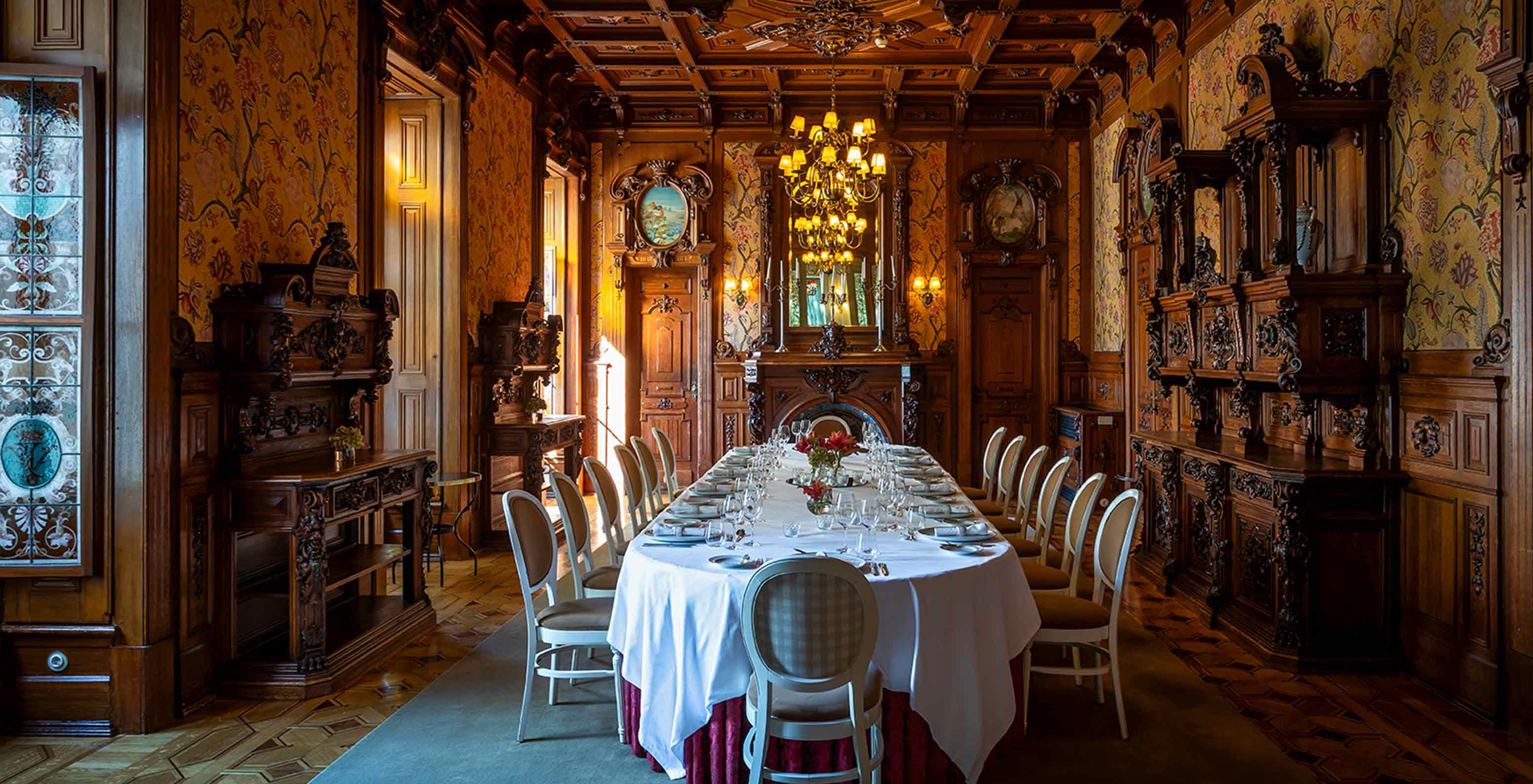 Pestana Palace Lisboa has a private dining room with a wooden ceiling, three chandeliers, and an oval table