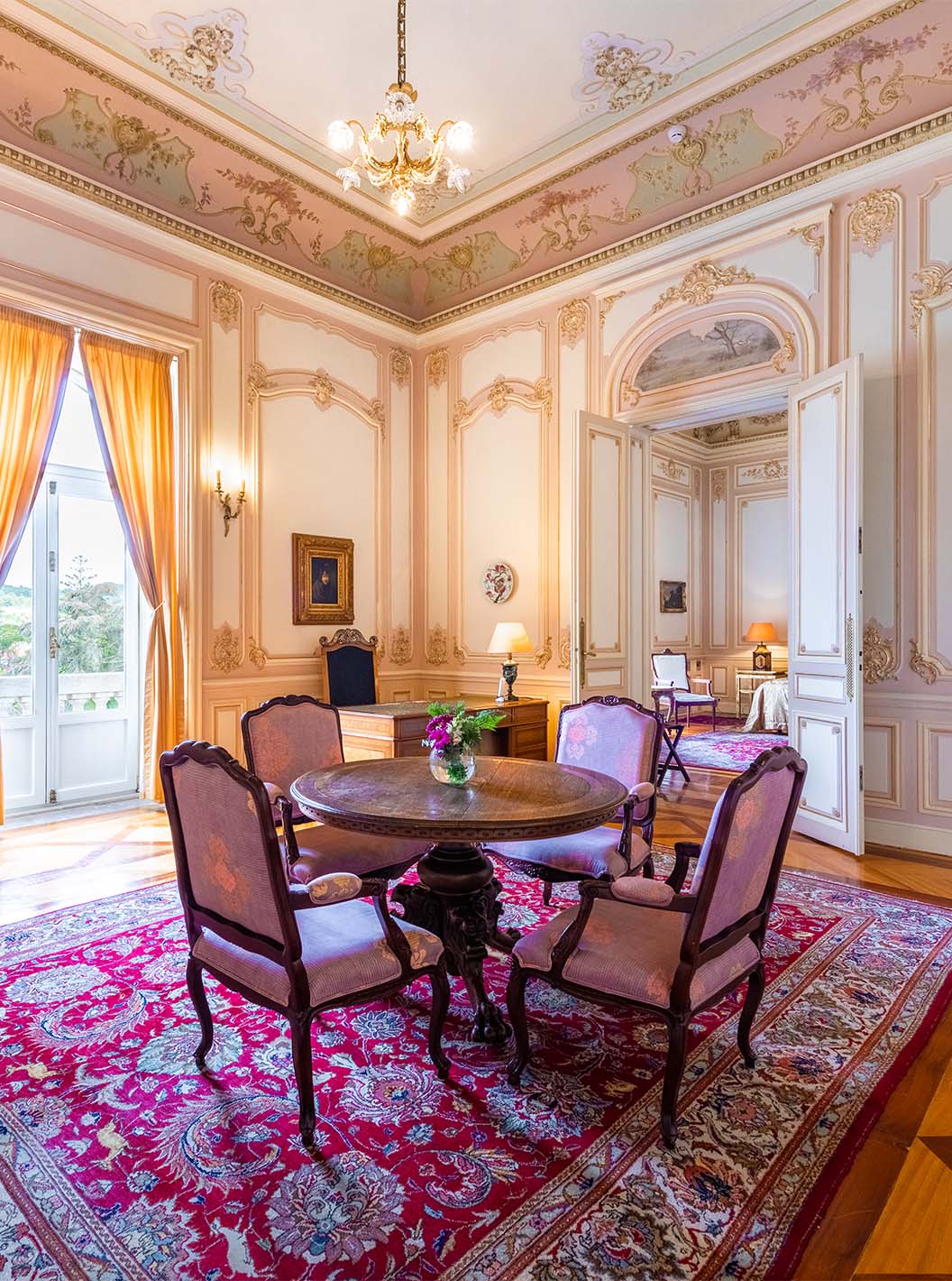 The Suite D. Carlos do Pestana Palace Lisboa has a large luxurious hall with one window and a dining table