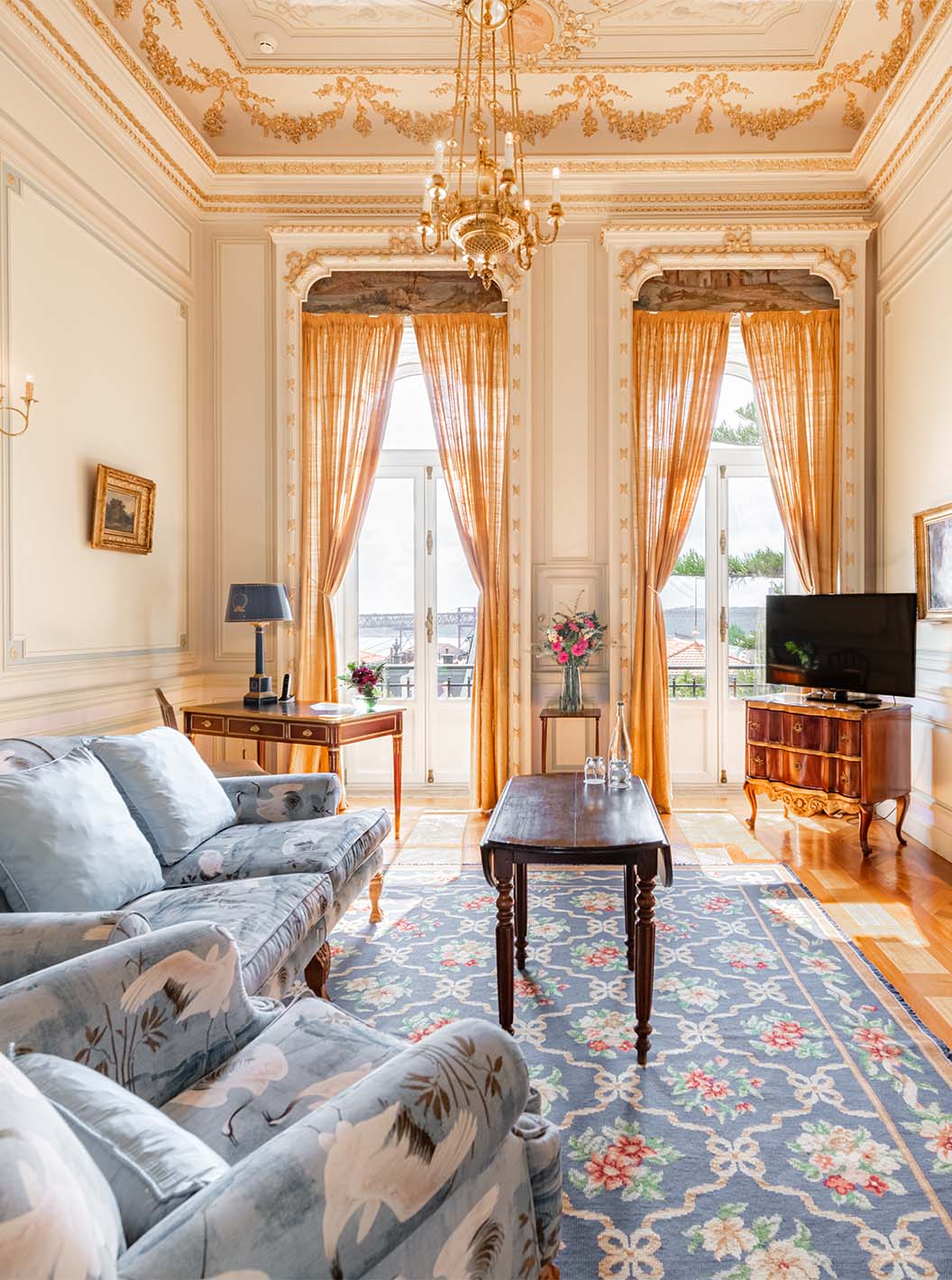 The Suite D. Manuel/D. Luís Filipe do Pestana Palace Lisboa has a luxurious living room with a sofa, TV, window and rug