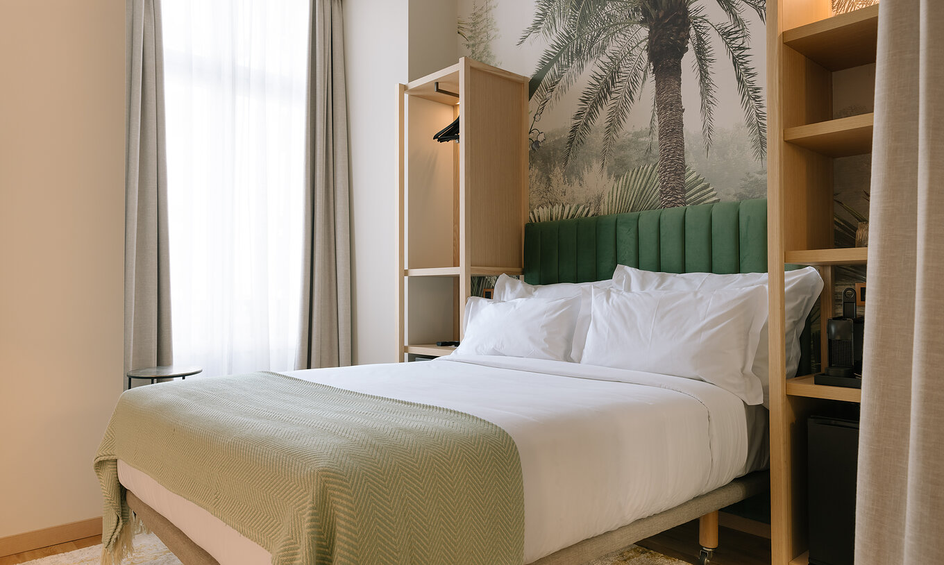 The Cozy of Pestana Rua Augusta Lisboa has a double bed with green suede headboard and two small wardrobes on each side