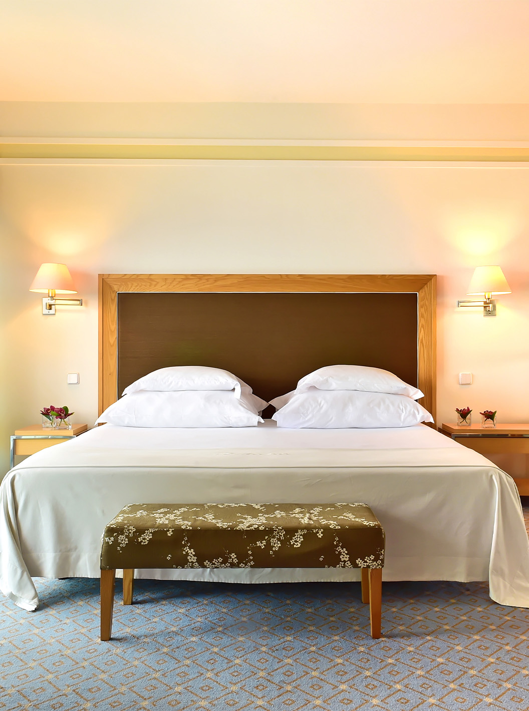 The Junior Suite at Pestana Carlton Madeira has a double bed with a bench at the foot and a wardrobe with mirrors