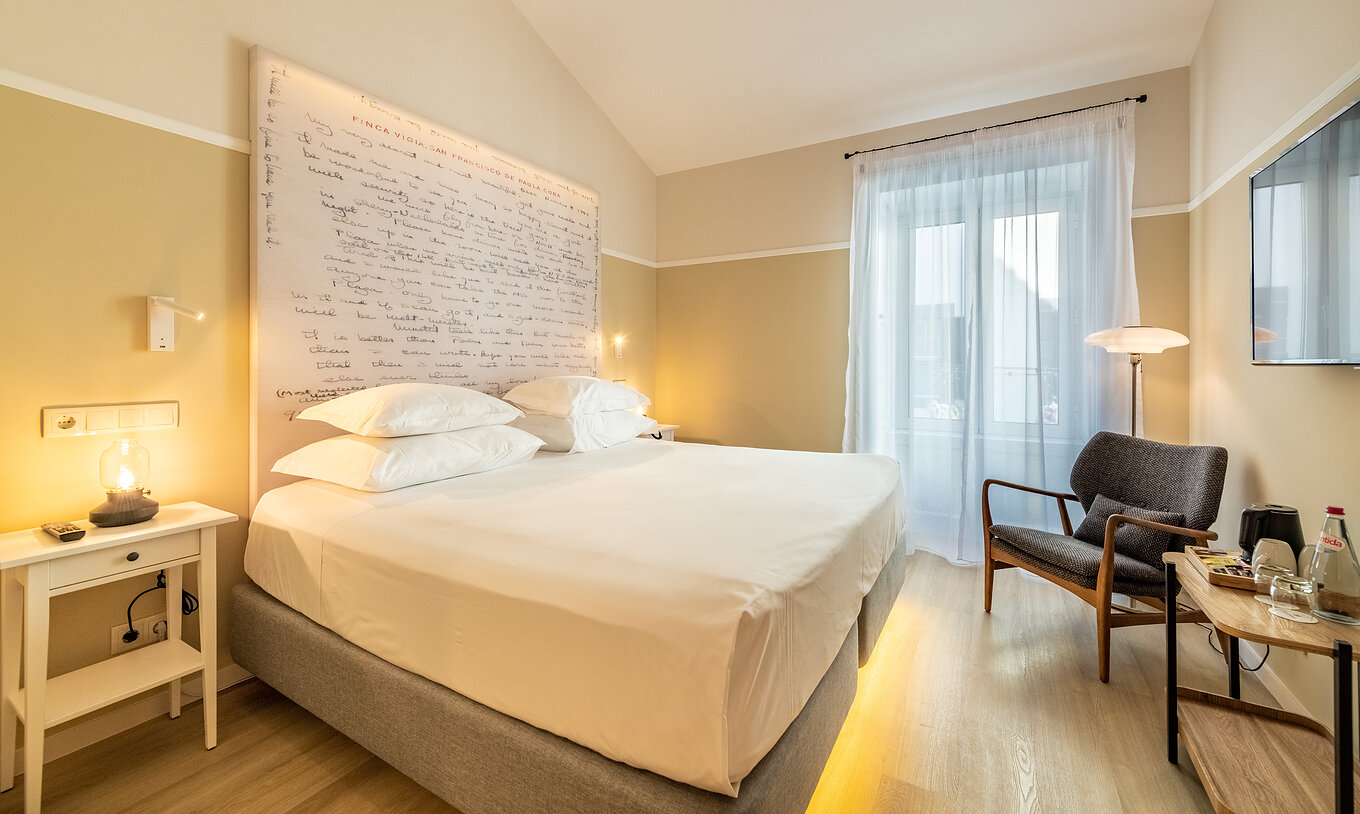 The Comfort room at Pestana Fisherman Village features a double bed with a headboard with written phrases and a window