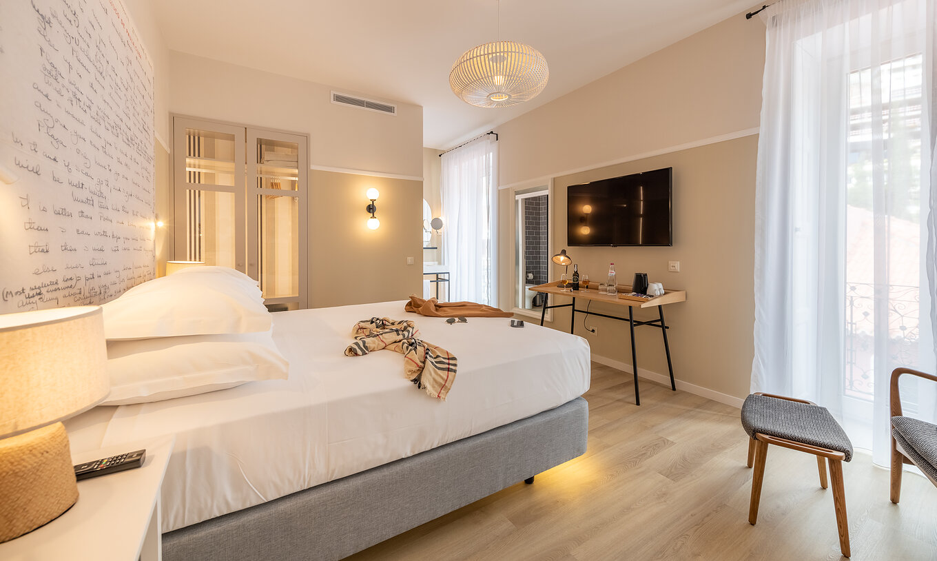 The Superior Family room at Pestana Fisherman Village has a double bed with a headboard with written phrases and a television