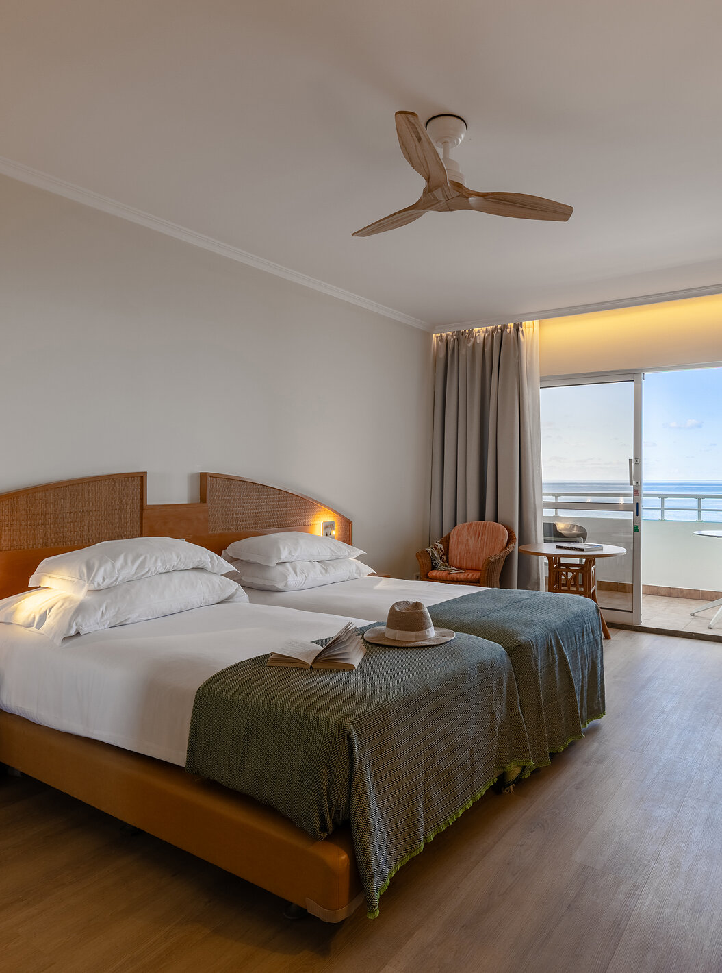 The Pestana Ocean Bay All Inclusive Classic Sea View has a double bed, a TV cabinet, two chairs, and a balcony with a view