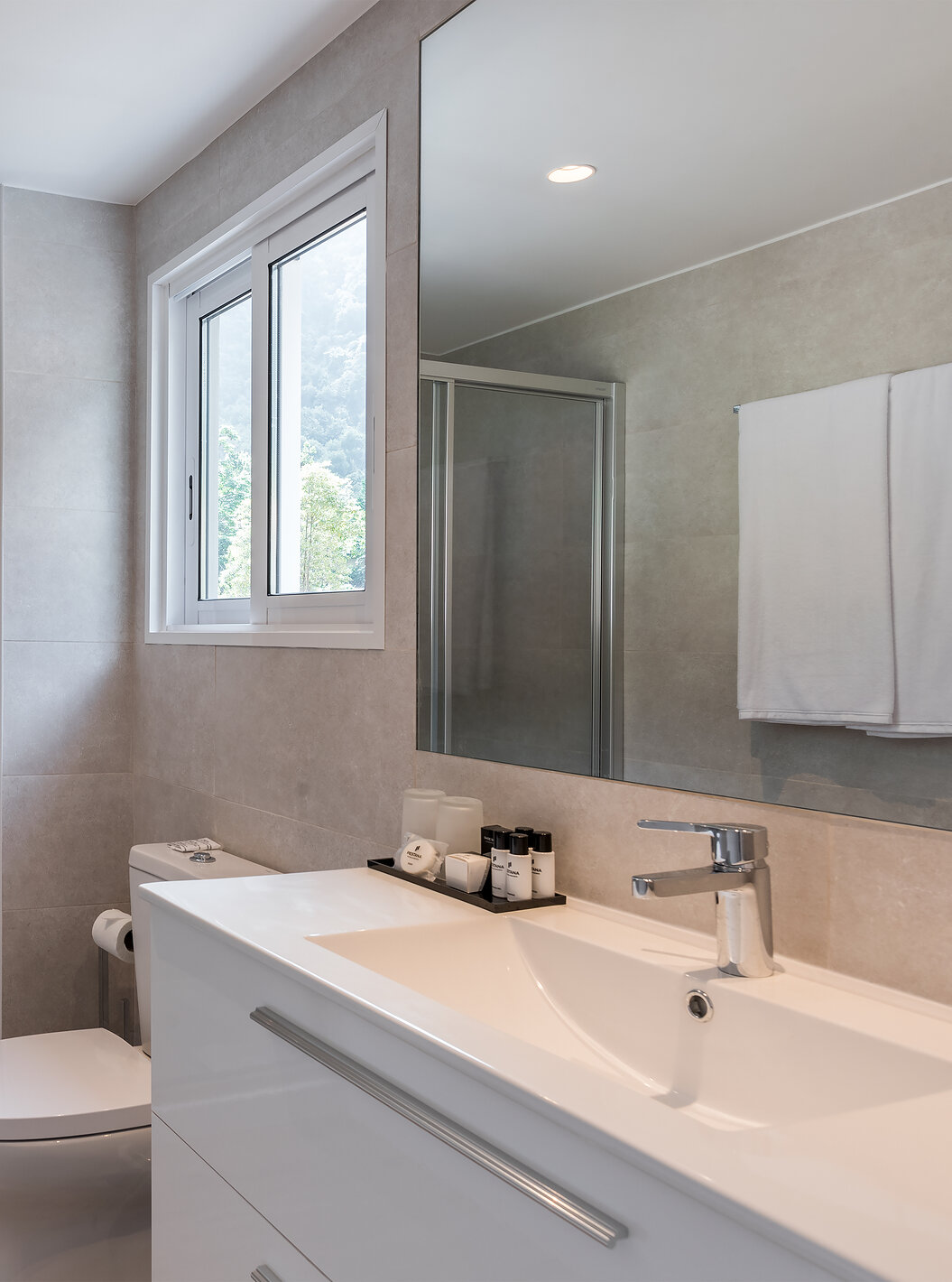 The Sea View Studio of Pestana Quinta do Arco has a bathroom with shower, toilet, sink with large mirror, and window