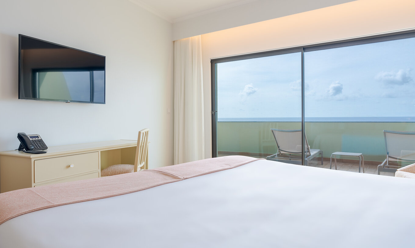 The Superior Sea View Suite at Pestana Vila Lido Madeira features a double bed with television and desk in front