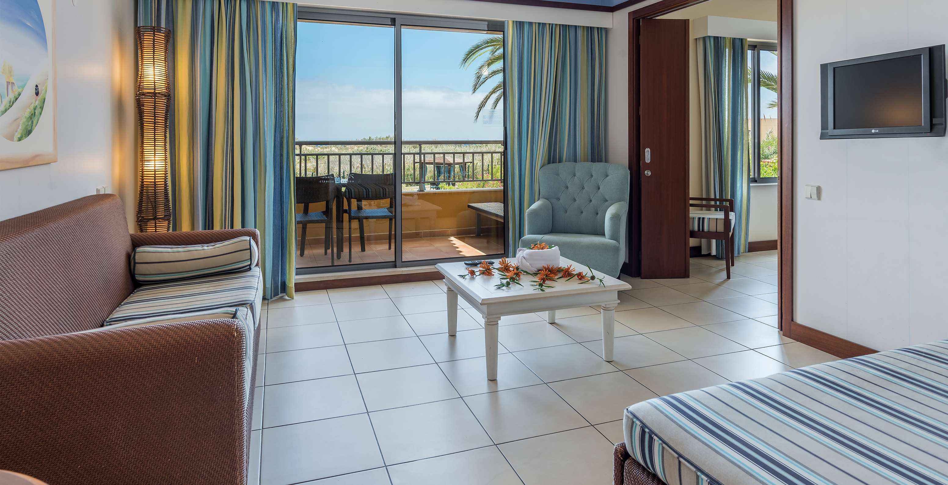 The T1 Suite Apartment of Pestana Porto Santo All Inclusive has a living room with access to the balcony, with garden view