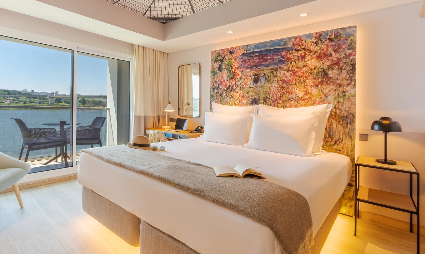 The Deluxe River View at Pestana Douro Riverside has a double bed, bedside table, and balcony with a view