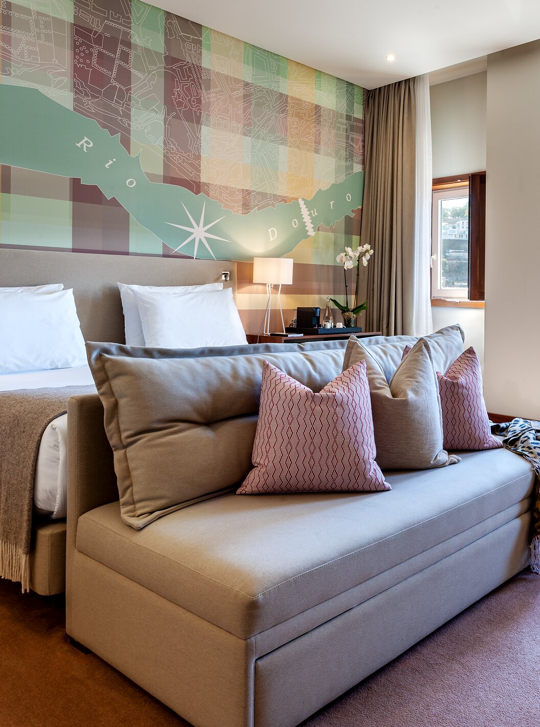 The Vintage Front View room at Pestana Vintage Porto has a double bed with a sofa at the foot, three windows and an armchair