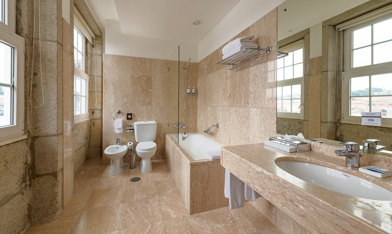 The Vintage Grand View room at Pestana Vintage Porto has a spacious bathroom with bathtub, toilet, sink and bidet
