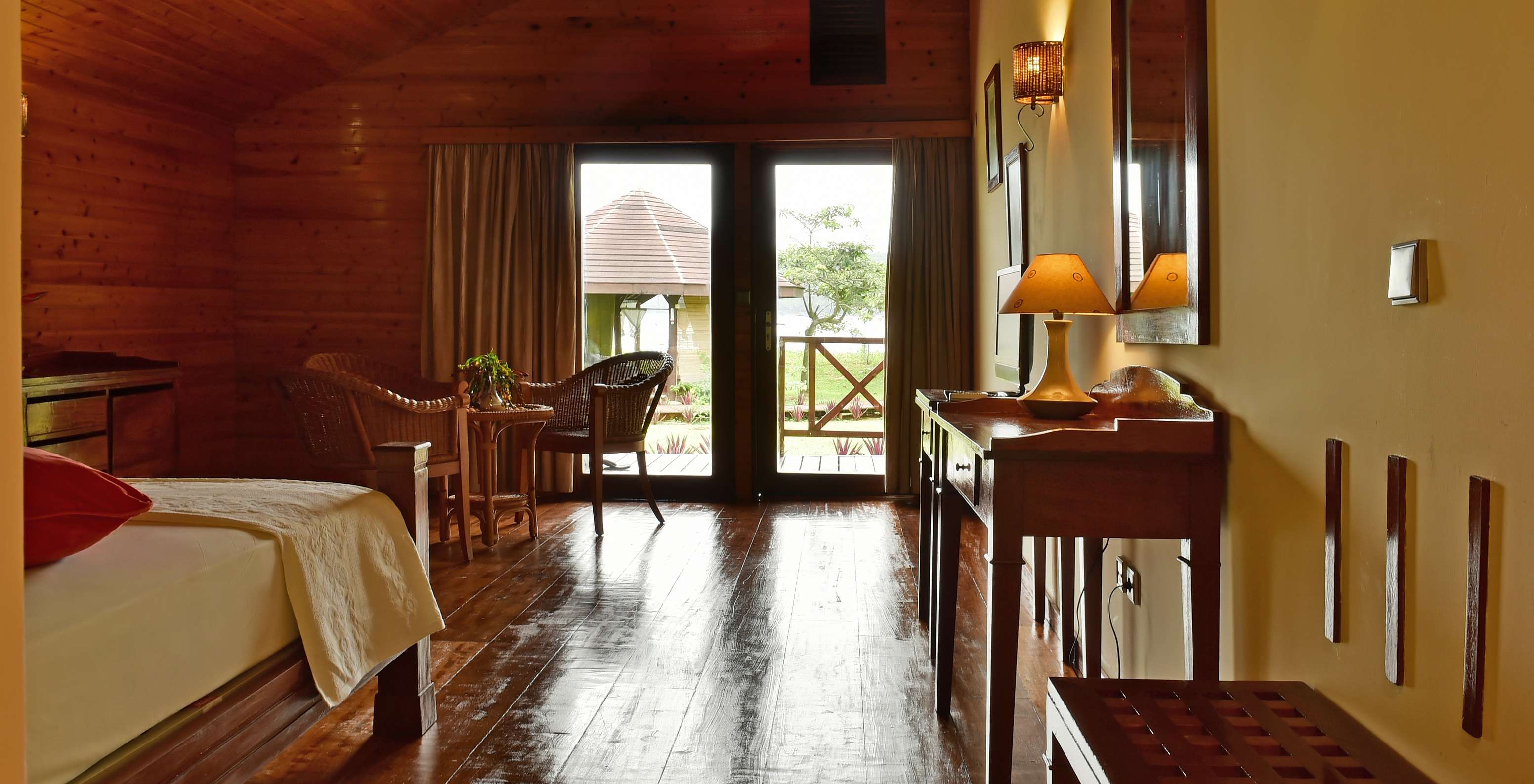 The Superior Double at Pestana Equador Ilheu das Rolas includes a wooden dresser, a mirror, and a window with a garden view