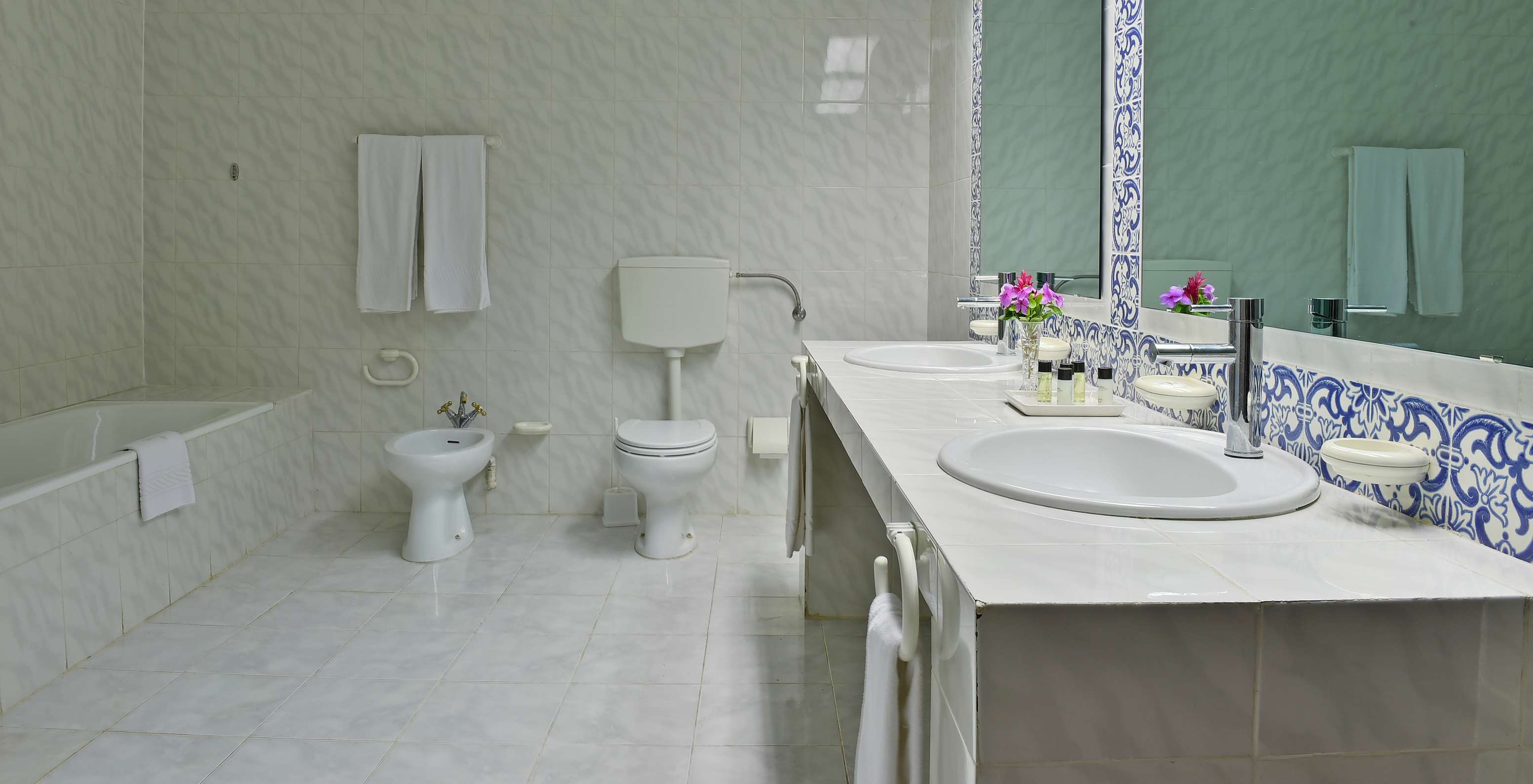 The Suite at Pestana Miramar São Tomé features a bathroom with tiled walls, sinks, mirrors, a bidet, and a toilet