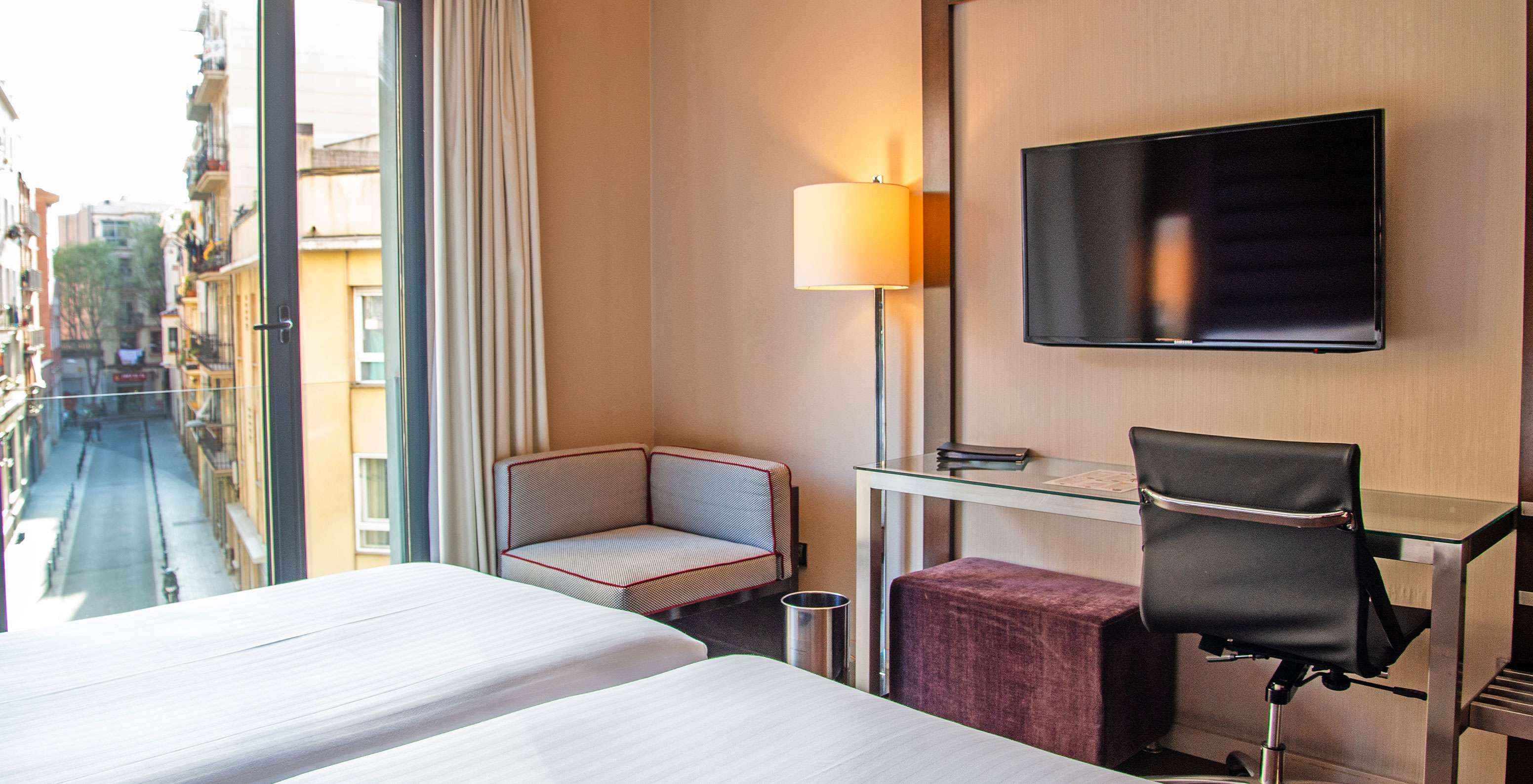 Standard Twin room at Pestana Arena Barcelona has a desk, TV, and a window overlooking the city center